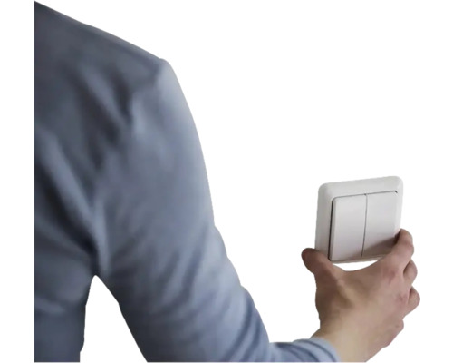 Een hand bedient een dubbele lichtschakelaar.