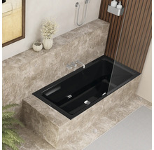 Zwart ligbad in een moderne badkamer met marmeren bekleding