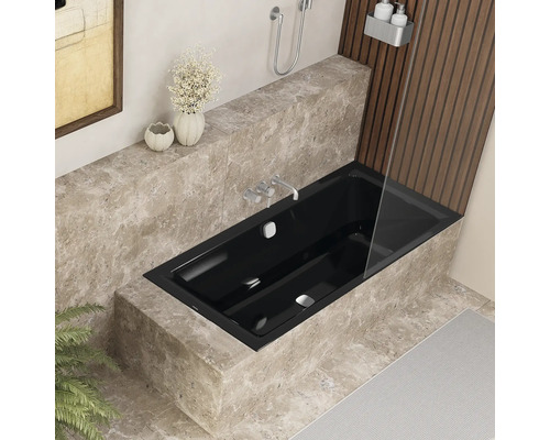 Moderne badkamer met zwart bad, marmeren bekleding en douchewand.