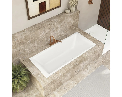 Moderne badkamer met ingebouwd ligbad, marmeren bekleding en stijlvolle kraan.