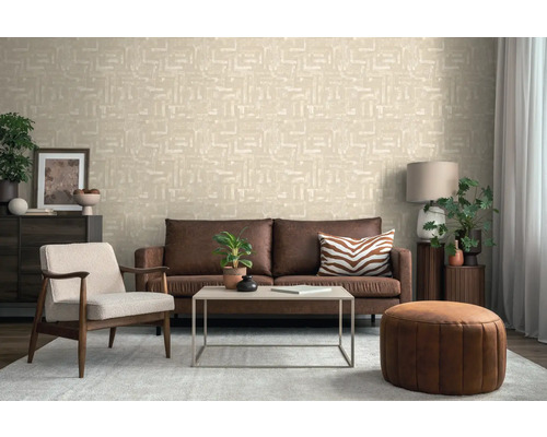 Woonkamer met bruine bank, fauteuil, tafel en patroonbehang