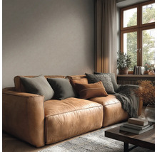 Woonkamer met leren bank, kussens en decoratie