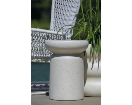 Decoratieve bijzettafel van steen met drankje en plant