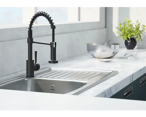 Keukenspoelbak met zwarte kraan en spiraalvormige slang