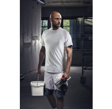 Vakman met T-shirt, korte broek, emmer en troffel op een bouwplaats