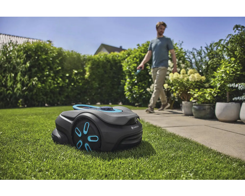 Gardena robotmaaier op gazon in tuin met man op de achtergrond