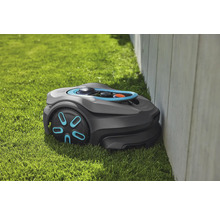 Robotmaaier op gazon naast een muur