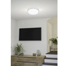 Moderne woonkamer met LED-plafondlamp, dressoir, televisie en kamerplanten.