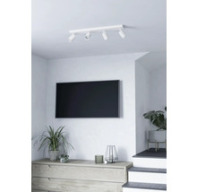 Woonkamer met plafondlamp met vier spots, televisie en dressoir