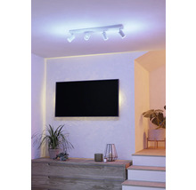 Woonkamer met flatscreen televisie, dressoir, kamerplanten en plafondlamp met meerdere spots