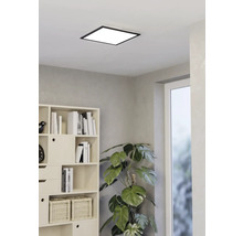 Vierkante plafondlamp in een lichte kamer met boekenkast en kamerplant