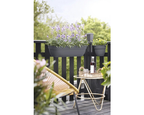 Balkonscène met beplante balkonbak en decoratie op een tafeltje.