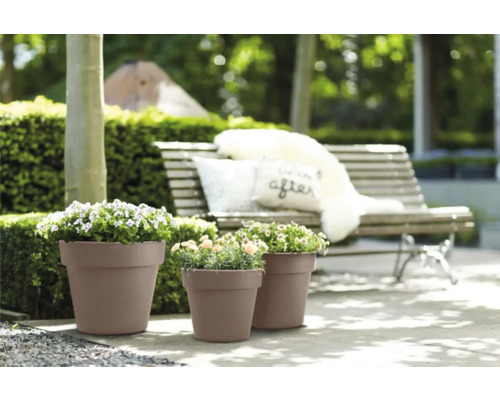 Drie plantenbakken met beplanting in de tuin