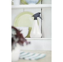 Kunststof spuitfles op een plank naast serviesgoed