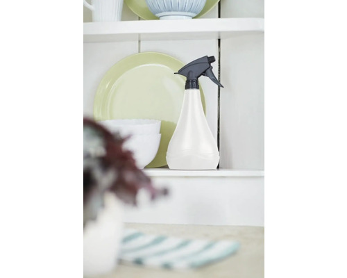 Kunststof spuitfles op een plank naast serviesgoed