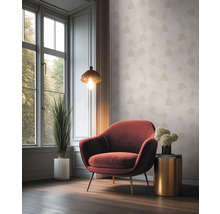 Woonkamer met fauteuil, lamp en kamerplant voor een raam