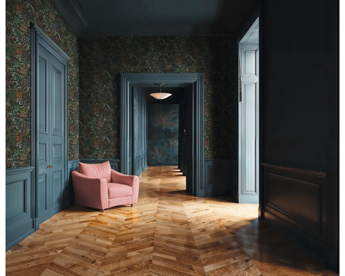 Gang met patroonbehang, houten vloer, deuren en een fauteuil