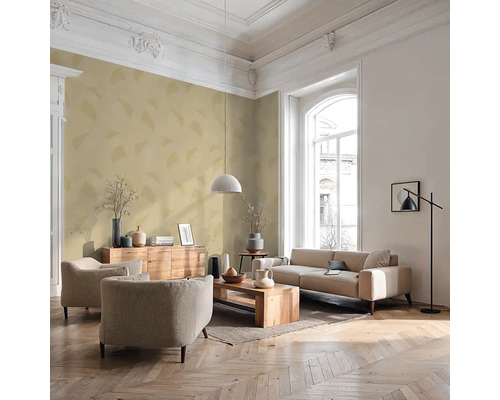 Lichte woonkamer met bank, fauteuils, houten tafel en decoratieve elementen.