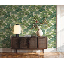 Woonkamer met behang met boommotief, houten dressoir, tafellamp en vaas