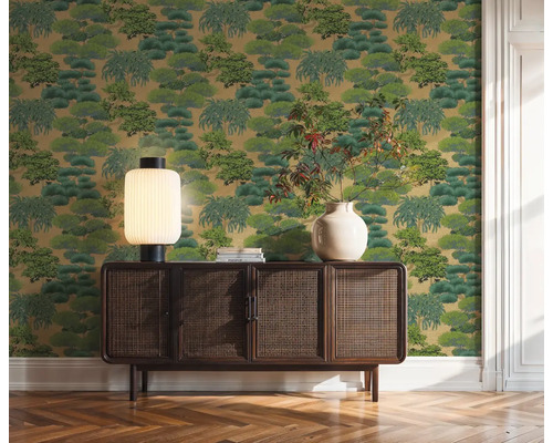 Decoratief groen behang met boommotief achter een houten kast in de kamer.