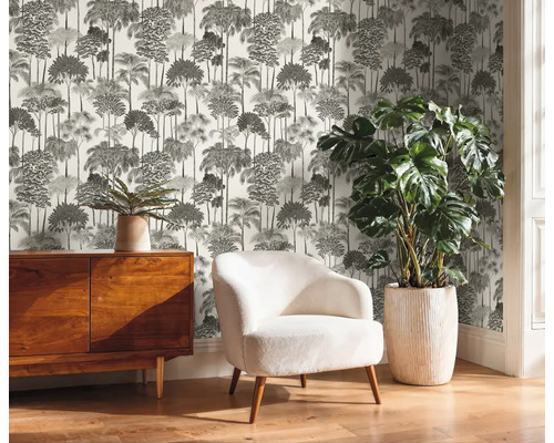 Kameroverzicht met dressoir, fauteuil, kamerplant en bedrukt behang met boommotief