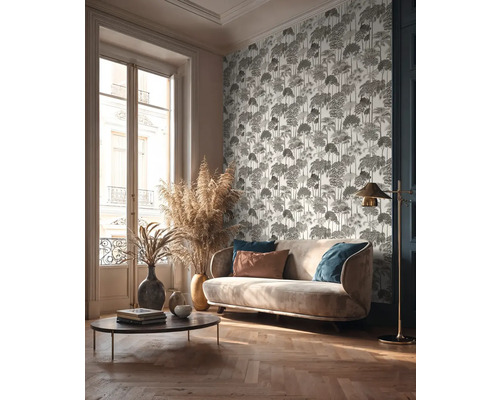 Woonkamer met bank, salontafel, staande lamp en behang met motief