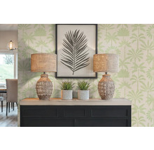Decoratieve scène met twee lampen, planten en een ingelijste foto op een dressoir voor een behang met palmmotief