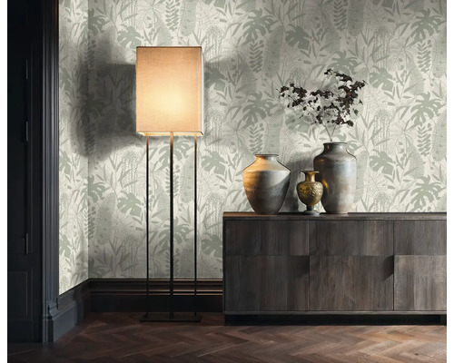 Woonkamer met botanisch behang, staande lamp en houten dressoir