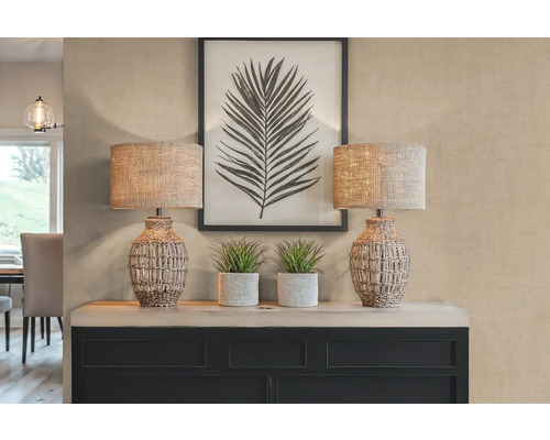 Decoratieve scène met twee tafellampen, planten en een ingelijste bladprint op een dressoir