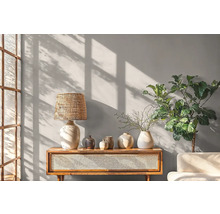 Lichte, vriendelijke inrichting met houten console, lamp, vazen en kamerplant.