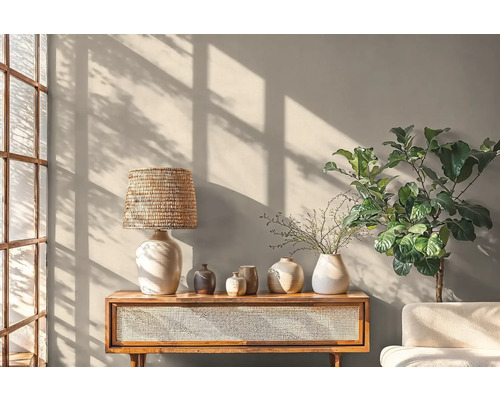 Woonkamer met lamp, vazen, plant en houten dressoir