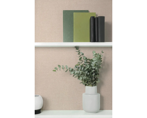 Boekenplank met boeken en een vaas met eucalyptus tegen een beige achtergrond