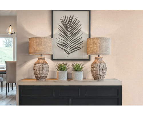 Decoratieve opstelling met twee tafellampen, planten en een ingelijste bladprint op een dressoir