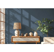 Woonkamer met houten console, tafellamp en decoratieve objecten.