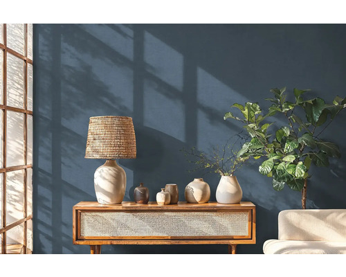 Woonkamer met houten console, tafellamp en decoratieve objecten.