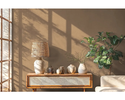 Woonkamer met houten tafel, lamp, diverse vazen en kamerplant