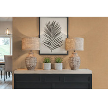 Decoratieve scène met twee lampen, planten en een ingelijste bladfoto op een kast