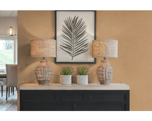 Decoratieve scène met twee lampen, planten en een ingelijste bladfoto op een kast