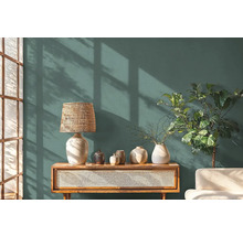 Woonkamer met een dressoir, een lamp, vazen en een kamerplant voor een muur