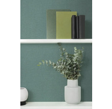 Wandplank met boeken en eucalyptus in vaas