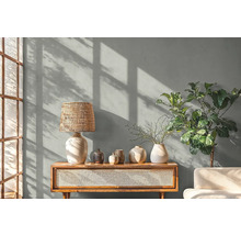 Woonkamer met tafellamp, decoratie en plant op een houten kast.