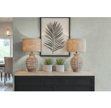 Decoratief interieur met twee tafellampen, kunstplanten en een ingelijste bladprint op een dressoir.