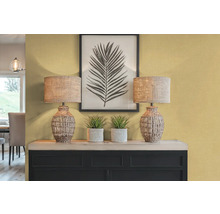 Decoratief interieur met twee tafellampen, planten en een ingelijste bladprint op een dressoir