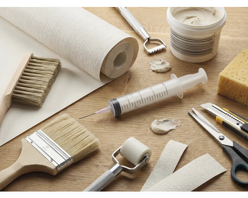 Gereedschap en materialen voor behangwerk op een tafel