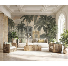 Fotobehang met palmbomen en koloniale gebouwen in een lichte woonkamer met witte bank, rotan fauteuils en houten salontafel.