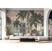 Lichte woonkamer met fotobehang in vintage stijl met palmbomen en koloniale gebouwen. Witte hoekbank, zwarte salontafel en gevlochten kleed.