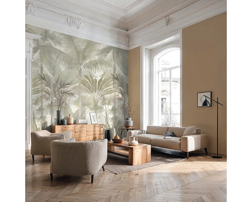 Lichte woonkamer met groot fotobehang met palmenmotief, bank, fauteuils, houten meubels en visgraatparket.