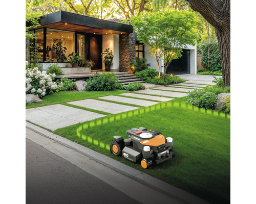 Robotmaaier op gazon voor huis met betegeld pad