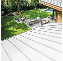 Overzicht van een tuin met barbecueplaats, zithoek en robotmaaier.