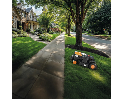 Een robotmaaier maait het gazon voor een woonhuis.